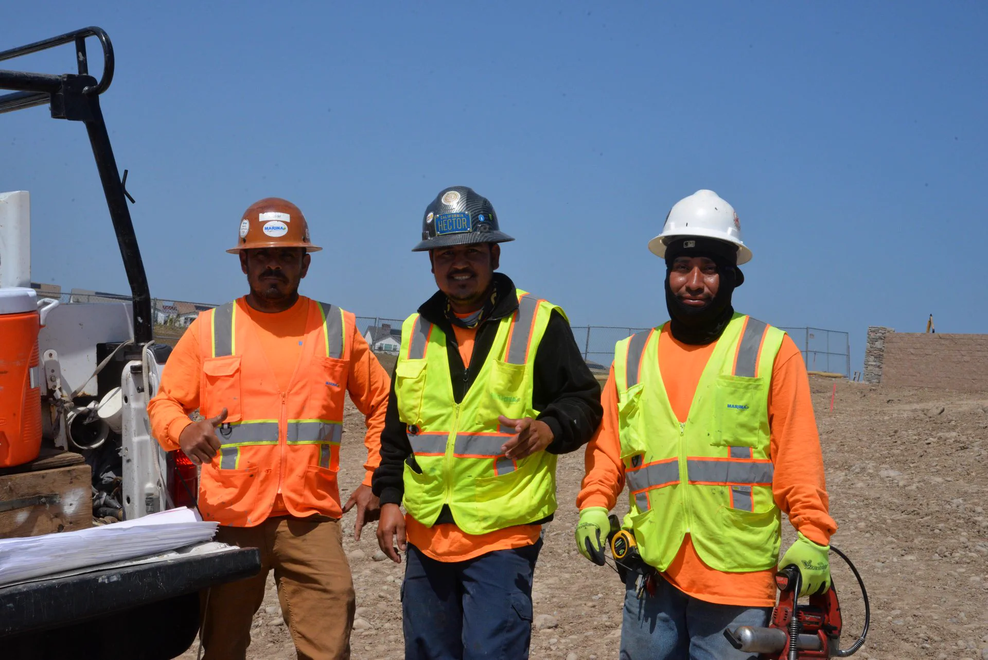 Marina crew on a grading site in hard hats and high-visibility vests