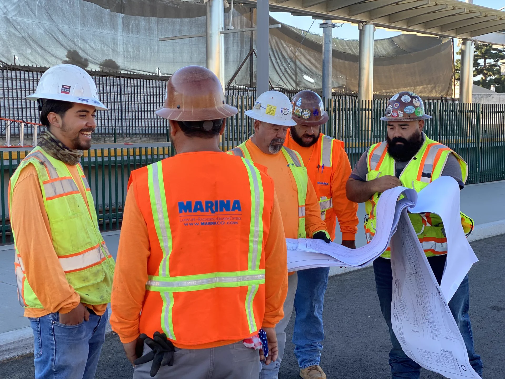 Marina crew in hard hats reviewing plans on site